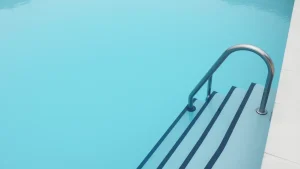 Γωνία πισίνας με ανοξείδωτη σκάλα και ήρεμη επιφάνεια νερού